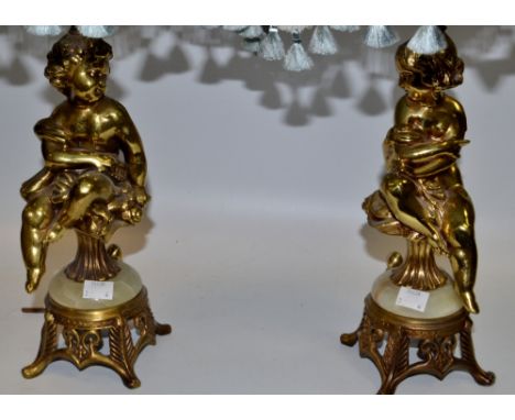 A pair of gilt metal lamp bases, scantily clad 30cm high