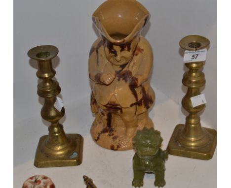 A jade Chinese Temple Lion; a pair of 19th century brass candlesticks; a stoneware treacle glazed Toby jug 