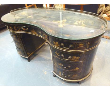 Large ebonised Oriental kidney shaped desk with twin four drawer pillars, ornate brass railing and raised and painted design,