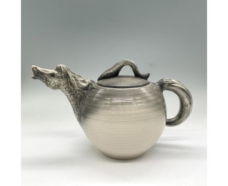Fun teapot with a horse head as the spout and tails for the handles. Glazed in grey fading down into light tan. Numbered 032.