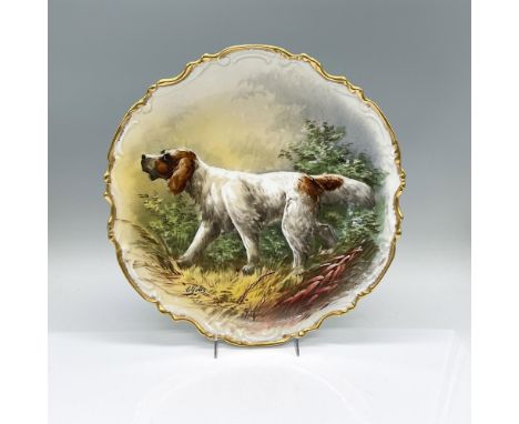 A gilt scalloped trim plate decorated with a hand painted scene of a hunting dog. Artist signed on the front. P.P. backstamp.