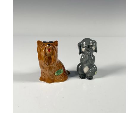 Porcelain hand painted dogs. First is praying. Impress mark 2130. The second happily wearing a blue bow. Impress mark 2102. G