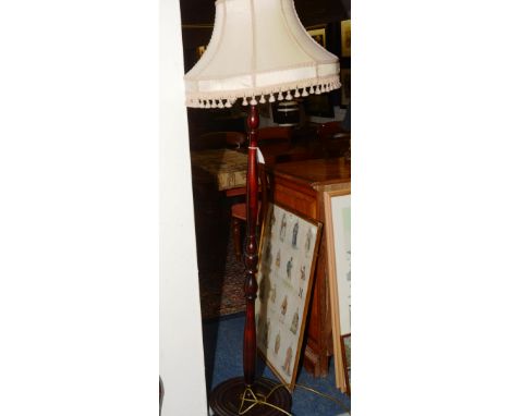 A stained wood floor lamp, with shade, having turned stem on circular base, 167cm high