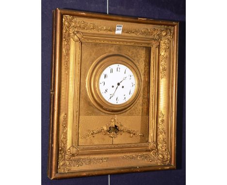 A late Victorian wall clock, with white enamel circular dial on gilt metal backing within a gesso style frame, decorated with