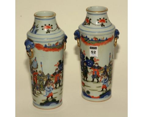 A pair of Chinese famille rose ceramic vases, decorated with multi coloured figures in foliage on a white ground, 26cm high. 