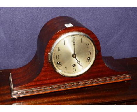 A 1940's stained wood mantle clock, of domed shape with silvered dial, 23cm high