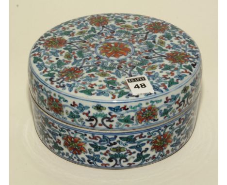 A Chinese ceramic circular jar with cover, decorated with multicoloured symbols in foliage , on a white ground, 19cm diameter
