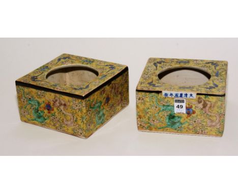 A pair of Chinese famille rose ceramic pots, with open inserts to top, decorated with colourful mythical beasts on a yellow g