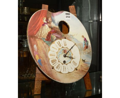 A Continental ceramic artists pallet clock, decorated with painted female figures and dog in a landscape scene, stamped to th