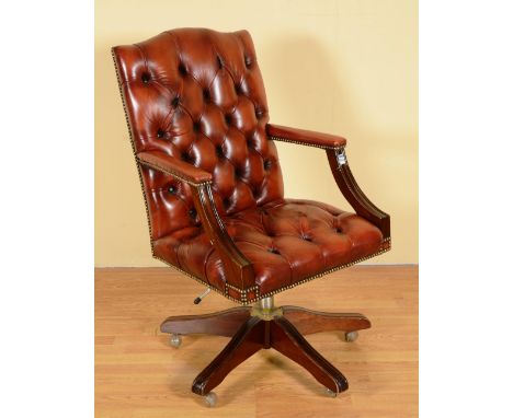 A red leather button back swivel desk chair, raised on four downswept supports, 103cm high x 60cm deep