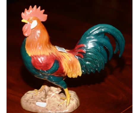 A Beswick Leghorn cockerel ceramic figure, painted in red, yellow and green, on a glazed base, 25cm high. CONDITION REPORT: L