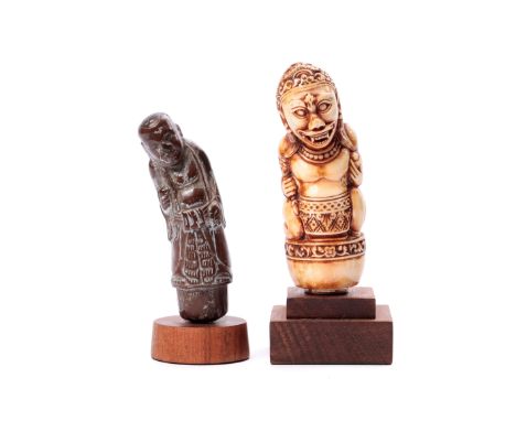 Bali, an hippo ivory kris hilt, showing a demonic figure; herewith a wooden Chinese standing figure. H. 11 and 10 cm., mounte