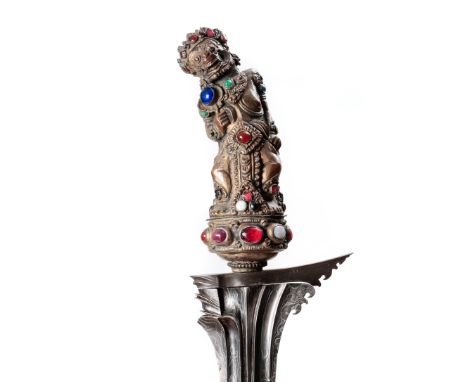 Bali, kris with a repousse metal togonan hilt, the hilt shaped as a deity, set with precious stone cabochons. The blade with 