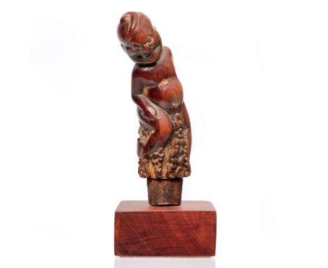 Bali, a wooden togonan kris hilt, depicting baby Bayu. H. 10,7 cm., mounted [1]
