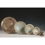 Persia, four glazed pottery dishes and an oil lamp, 14-17th century,