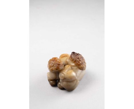 A CHINESE RUSSET JADE CARVING OF TWO BUDDHIST LIONSQING DYNASTYModelled as two muscular beasts, one playfully clawing the oth