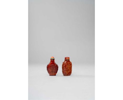 λ λ TWO CHINESE AMBER SNUFF BOTTLES 19TH CENTURY  One carved to each side with two dragons contesting a sacred pearl amidst f