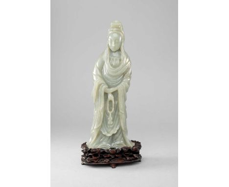 A LARGE CHINESE CELADON JADE CARVING OF GUANYINREPUBLIC PERIODThe Goddess standing with a serene expression, wearing long flo