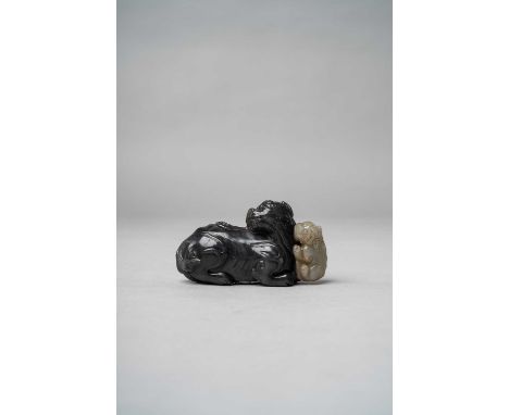 A CHINESE BLACK AND GREY JADE 'BUDDHIST LION AND PUPPY' GROUPQING DYNASTY OR LATERThe larger beast carved in black jade, recu