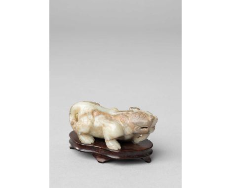 A CHINESE CELADON JADE CARVING OF A TIANLUQING DYNASTY OR LATERThe crouching beast with a single horn, his bifurcated tail cu
