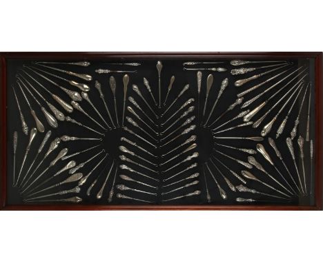 Three display cases, late 19th Century, displaying a large collection of silver button hooks, and glove stretchers, the large