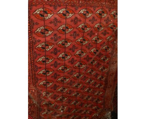 A madder ground Turkmen carpet, having five rows of elephant pad medallions to centre, multi-bordered and fringed, L. 276, W.