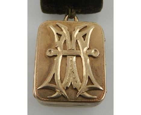 A yellow gold Victorian double portrait pendant, of rectangular form, monogrammed to front, suspended on a brown velvet choke