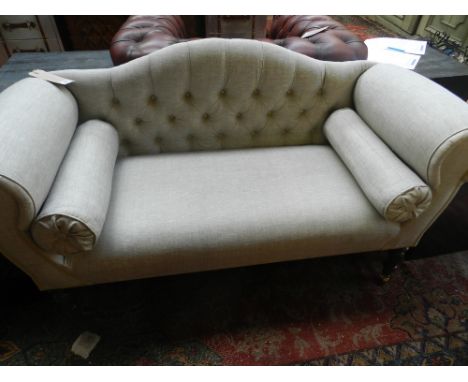 A Victorian style camel back sofa, raised on casters.