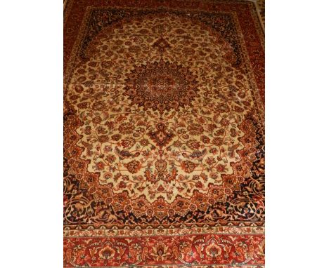 A Keshan style carpet, having a central medallion on a cream and red ground, contained by many borders. L.230cm W.160cm