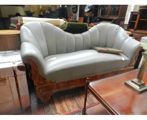 A Spanish Art Deco camel back sofa, stuff-over upholstered with grey leather, burr walnut shell and floral carved frame, rais