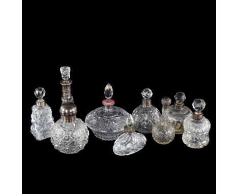 A group of 9 silver-mounted perfume bottles, including 1 with a pink enamel collar, tallest 17cm (9)The square bottle has a c