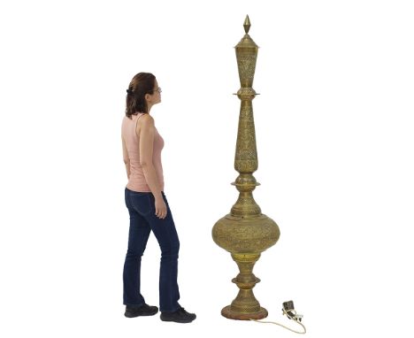 A Moroccan hammered and pierced brass floor lamp on wooden base with interior lights, measuring H185cm, W40cm, circa 1920s.