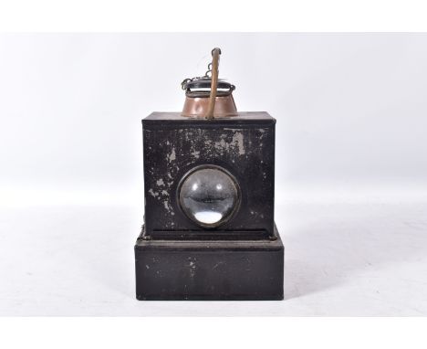A RAILWAY HAND LAMP, reservoir, burner and wick to base, clear bullseye lens, copper chimney, painted black, stamped B.R. (M)