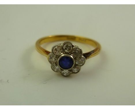 A SAPPHIRE AND DIAMOND FLORAL HEAD CLUSTER RING having single sapphire and eight brilliants around, on a yellow gold shank st