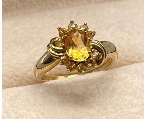 9ct yellow gold ring set with an oval cut citrine flanked by yellow tourmaline stones. [Ring size M] [3.22GRAMS] 