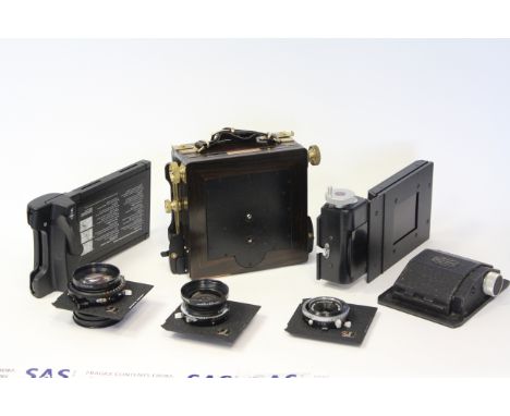 A Wista Field Camera, wood and brass with 3 lenses, Polaroid, rollfilm and sheet film holders and other accessoriesin a home 
