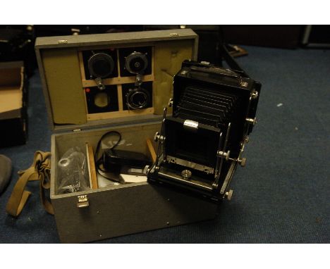 An Unmarked 5x4" Press Camera, with three various lenses moutned on boards, with various accessories in maker's case (a lot)