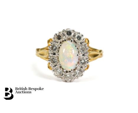 An 18ct yellow gold opal and diamond ring. The ring set with an oval opal 8 x 5mm, surrounded by 45 pts of dias, size M, appr