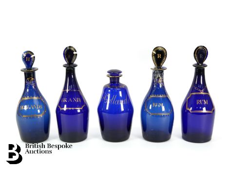 Five Georgian Bristol blue glass decanters and stoppers, comprising a pair of club shaped decanters, each with a painted gilt