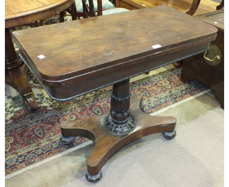 A 19th century rosewood fold-over card table on turned and carved column, above a platform base with bun feet, 91cm wide.