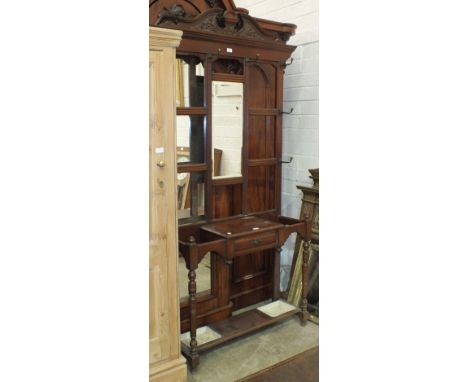 An Edwardian mahogany hall stand with central rectangular mirror plate above a glove box fitted with a drawer, flanked by sti