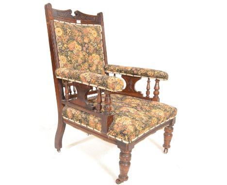 A Victorian 19th century mahogany library armchair. Raised on turned legs with castors having a tapestry upholstered seat wit