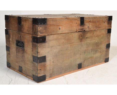 A 19th Century ebonised pine blanket box / trunk chest, carry handles to the sides with hinged top above raised on a plinth b