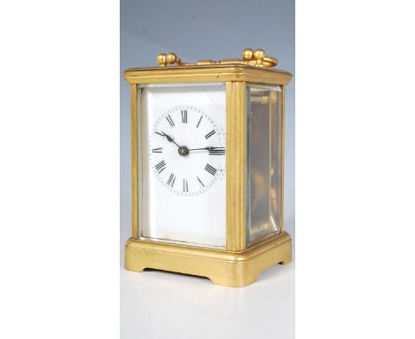 A 19th Century antique brass cased carriage clock raised on a plinth base with reeded supports, having glass panels to the si