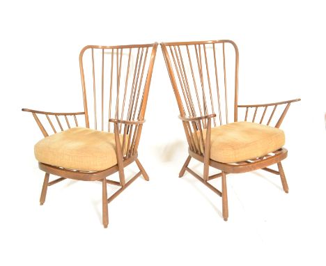 Ercol - A 20th century Windsor pattern pair of armchairs in beech and elm golden dawn having shaped&nbsp; armrests and spindl