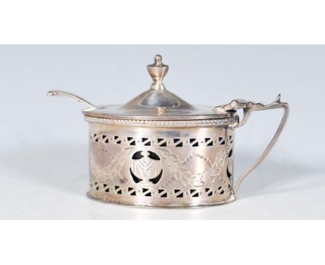 A late 19th Century high Victorian silver hallmarked mustard pot of oval form having shaped handle with the body having pierc