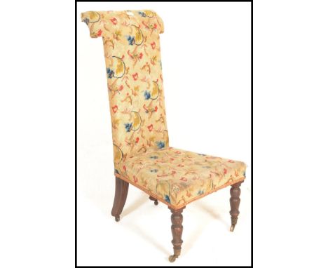 A 19th Century Victorian prie dieu / prayer chair upholstered in a floral tapestry material having turned mahogany front legs