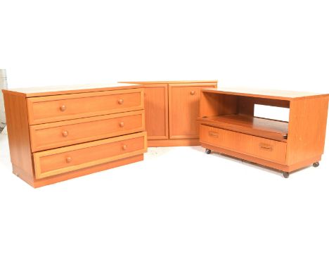 A retro 20th Century G-Plan chest of three straight drawers with turned handles raised on a plinth base and matching two door