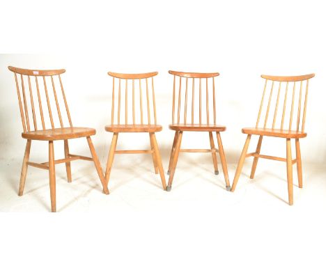 In the manor of Ercol - A set of four 20th Century vintage beech and pine stick back dining chairs having a rounded seats and