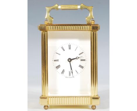 A vintage brass Carriage Clock of five-glass form, English made, white enamel face having a Roman numeral chapter ring stampe